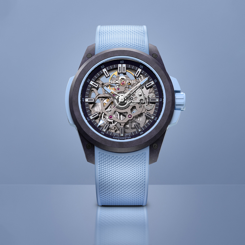 На фото: часы NORQAIN Independence Wild One в 39 мм корпусе из композитного углеродного материала Norteq со скелетонизированным циферблатом и голубым каучуковым ремешком На фото: часы NORQAIN Independence Wild One в 39 мм корпусе из композитного углеродного материала Norteq со скелетонизированным циферблатом и голубым каучуковым ремешком