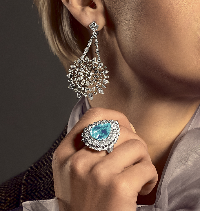 Модель в серьгах Green Carpet из белого золота с бриллиантами и кольце High Jewellery из белого золота с турмалином параиба и бриллиантами, все Chopard