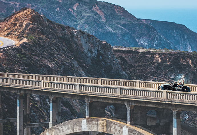 Автомобили пересекают Bixby bridge во время парада Pebble beach tour D'elegance